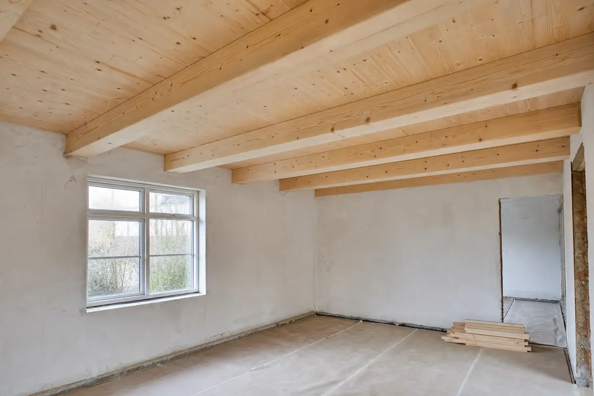 Nyt træloft med lyse spær og bjælker i et rum under renovering